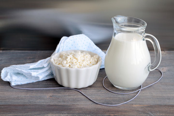 Fresh cottage cheese and milk on wooden kitchen table