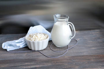 Fresh cottage cheese and milk on wooden kitchen table