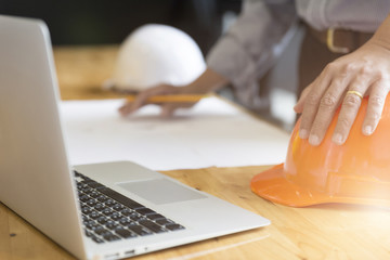 Architect working on blueprint of construction project in workpl