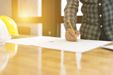 Architect working on blueprint of construction project in workpl