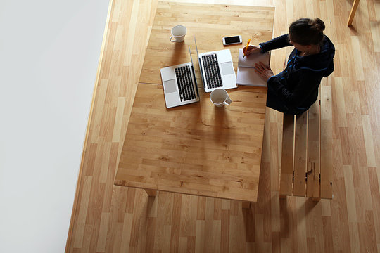 junge Frau sitzt am Schreibtisch von oben - Powered by Adobe