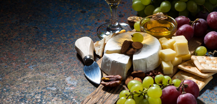 camembert, grapes and crackers and dark background