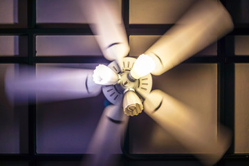 Motion blur of spinning ceiling fan with lamp