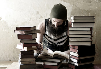 Men reading behind pile of books - Mann mit Vollbart liest hinter einem Bücherstapel