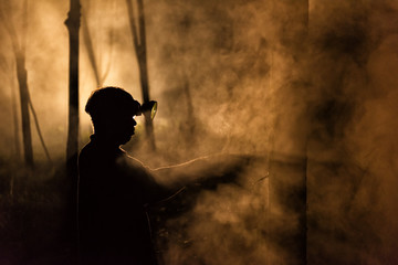 Man Tapping Rubber Tree at Night