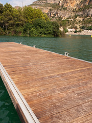 Paisaje de un lago con un muelle de madera. Vista de frente. Formato vertical