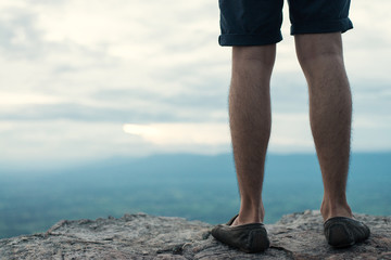 Man standing on edge of a cliff mountain top , travel concept.
