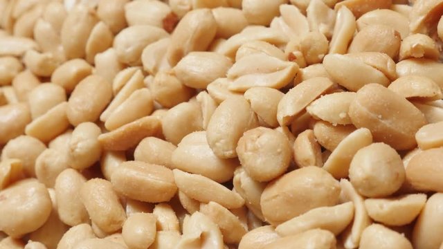 Arachis hypogaea groundnut close-up slow tilting food background 4K 2160p UltraHD video - Popular snack roasted and salted peanuts pile 4K 3840X2160 UHD tilt footage 