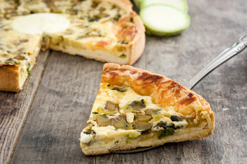 French quiche Lorraine with vegetables on a rustic wooden table

