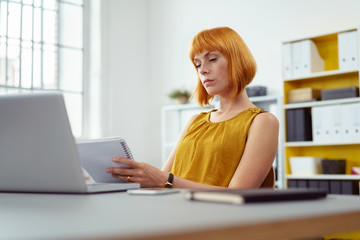 frau im büro macht sich notizen auf einem block © contrastwerkstatt