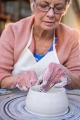 Close-up of female potter making pot