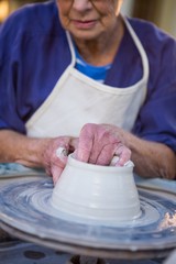 Close-up of female potter making pot