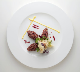 Dish with quenelle of red rice, fish tempura and sprouts