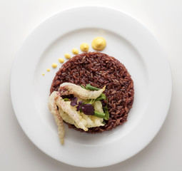 Dish of red rice, fish tempura and sprouts