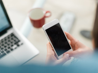 Pretty young business woman using mobile phone in startup office