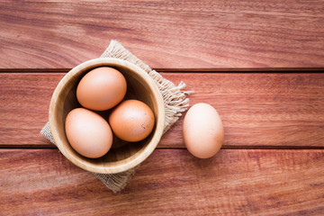 Eggs in bowl on rustic wooden background