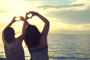 two hands of a heart-shaped women hurled into the sky by the sea
