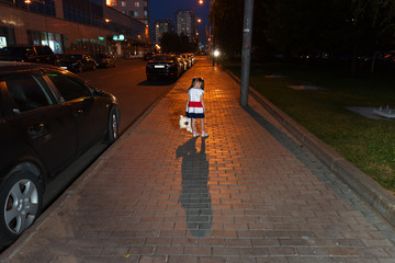 Маленькая девочка стоит одна в ночном городе