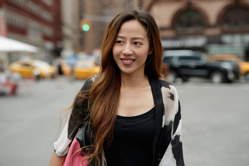 Young Asian woman in city walking smile happy face
