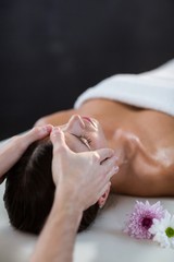 Naklejka premium Male physiotherapist giving head massage to female patient