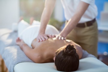 Obraz na płótnie Canvas Male physiotherapist giving back massage to female patient