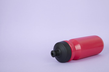 A pink sports water bottle on a purple background forming a page border