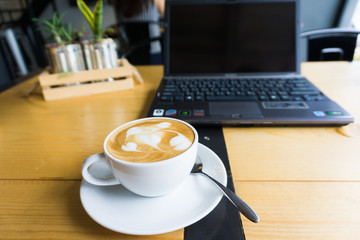 Latte art coffee cup and laptop for business.