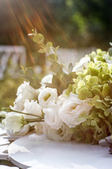 White wedding flowers on white table outdoors