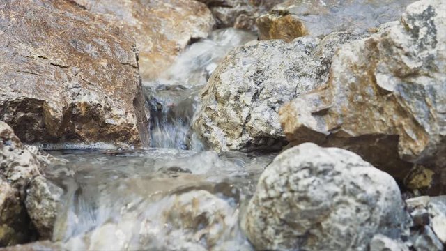 Kleiner Bach im Gebirge, mit sauberem und klarem Wasser aus einer Quelle im Gestein. Erfrischendes Quellwasser für Wanderer in den bayerischen Bergen und Alpen.