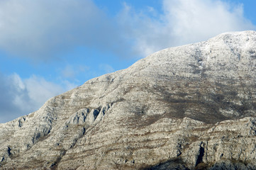 Mountain slope in a winter cloudy day. A fragment of the Odijevo mountain range on Mount Orjen, located on the coast of Montenegro in the vicinity of the town of Herceg Novi.