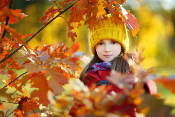 Cute little girl having fun on beautiful autumn day