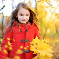 Cute little girl having fun on beautiful autumn day