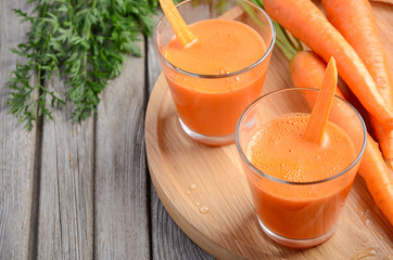 Fresh carrot juice on wooden background, selective focus, copy space