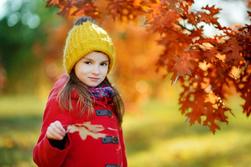 Fototapeta premium Cute little girl having fun on beautiful autumn day