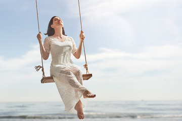 young woman on a swing - obrazy, fototapety, plakaty