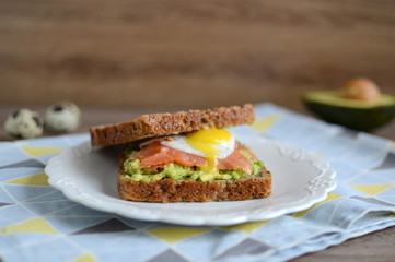 Sandwich with avocado, smoked salmon and quail egg