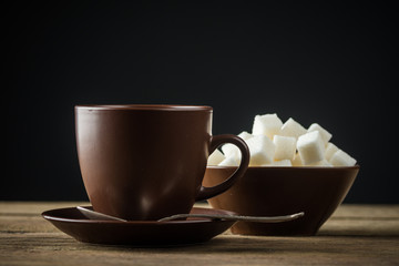 coffee cups, beans and sugar on rustic wooden table background
