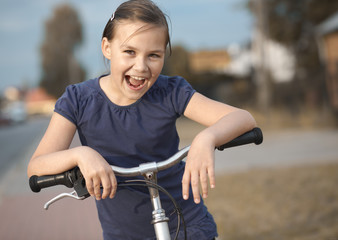 Obraz premium Cute girl is sitting on bicycle