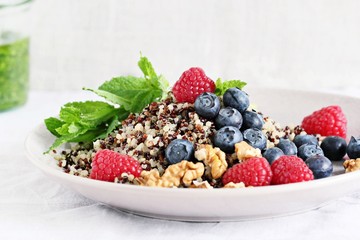 Quinoa salad with fresh berries,walnuts and mint lime honey dressing.Superfoods and clean eating concept. 
