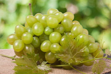 bunch of green grapes on sackcloth with a blurred background