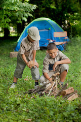 excited children on a camping trip learn how to light a fire
