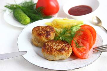 Fried cutlets with potatoes on a white plate.