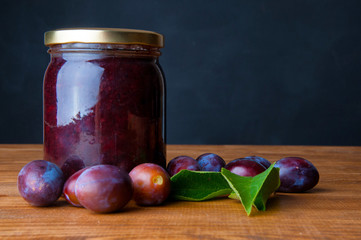Fresh plum jam on a wooden background