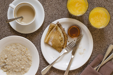 Oatmeal pancakes fresh orange juice coffee and scrambled eggs for breakfast  