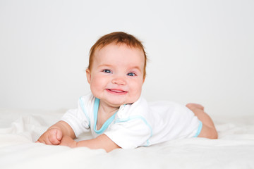 Funny little baby lying down on a blanket . Newborn child relaxing in bed. Nursery for young children. Textile and bedding for kids.

