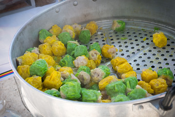 Chinese steamed pork dumpling in green and yellow color. Easy snack street food in Thailand. 