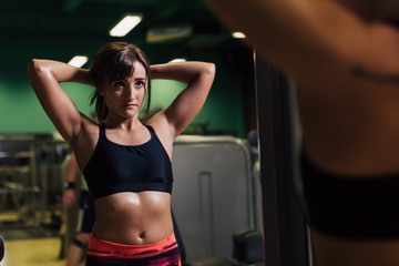 Young woman at the gym getting ready for exercising in front of a mirror
