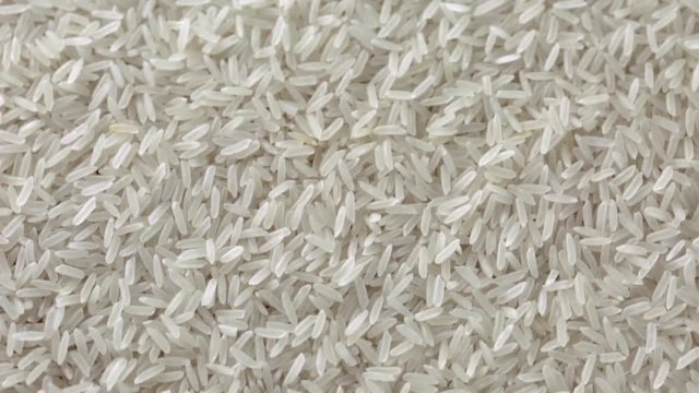 Rotating dry uncooked rice. Spinning closeup seeds. 1280x720. Slow Motion
