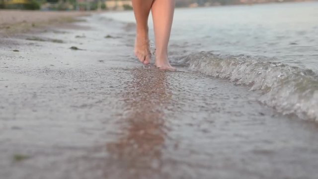 a girl keeps along the shore on water womanish feet