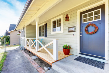 Nice covered porch with blue entrance door